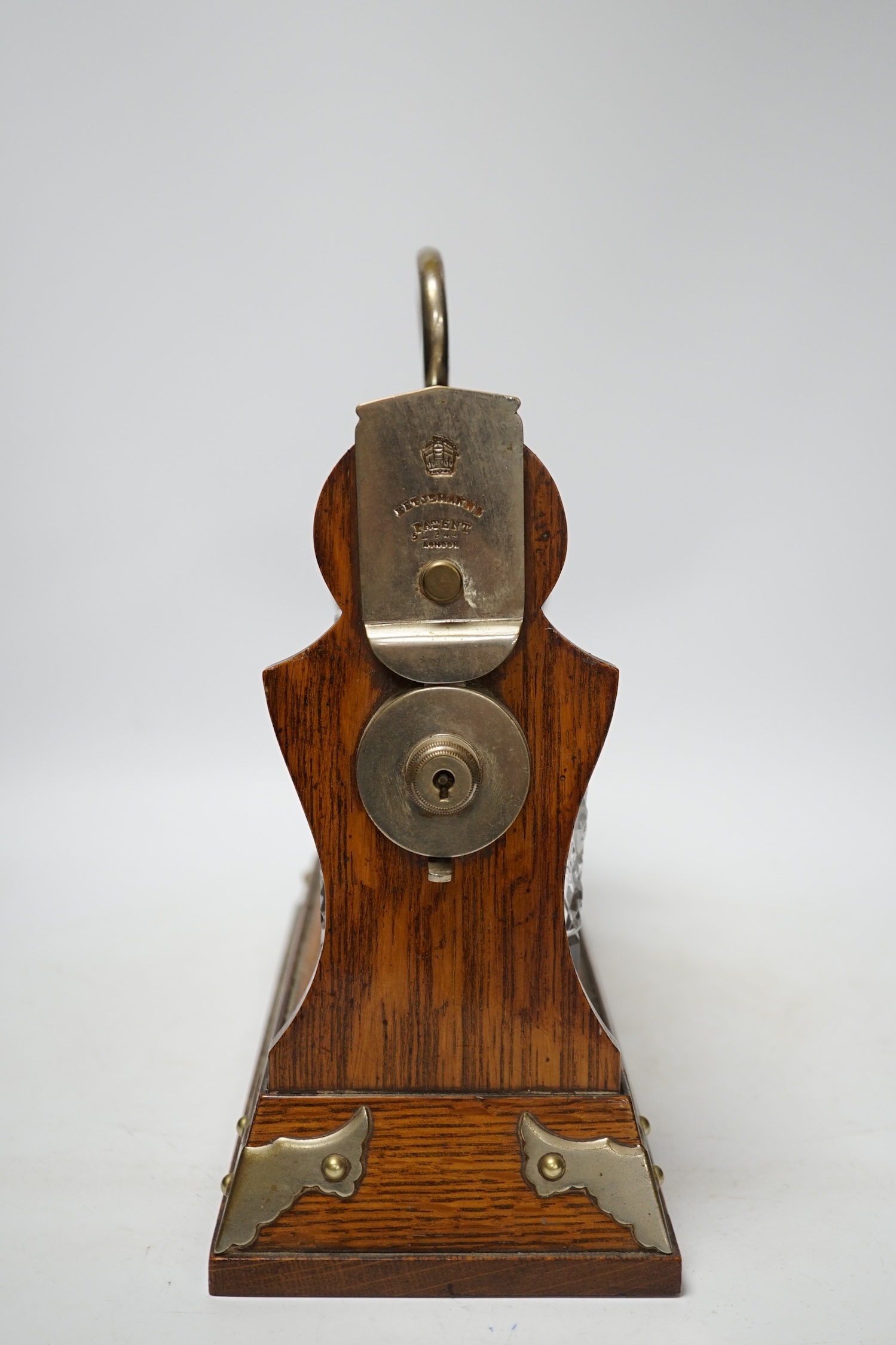 A Betjemann’s patent oak three bottle tantalus without key, 32cm wide